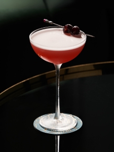 Cocktail Mary Pickford, présenté dans un verre à cocktail décoré de deux cerises confites.