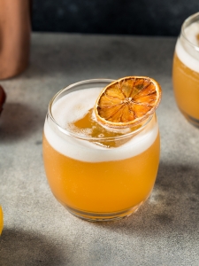 Cocktail Pussyfoot sans alcool, décoré d'une tranche d'orange.