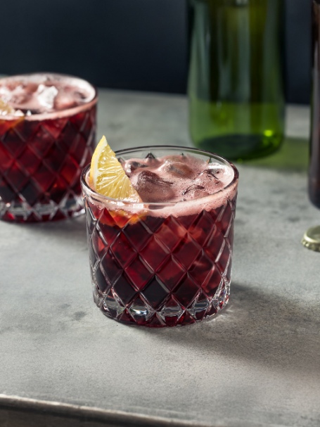 Cocktail Calimucho, à base de vin rouge et cola, servi dans deux verres old fashioned remplis de glaçons.