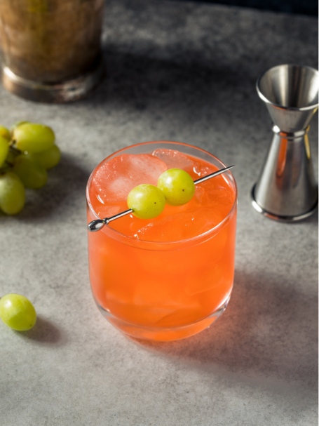 Cocktail Enzoni, dans un verre short drink garni de deux grains de raisin blanc.