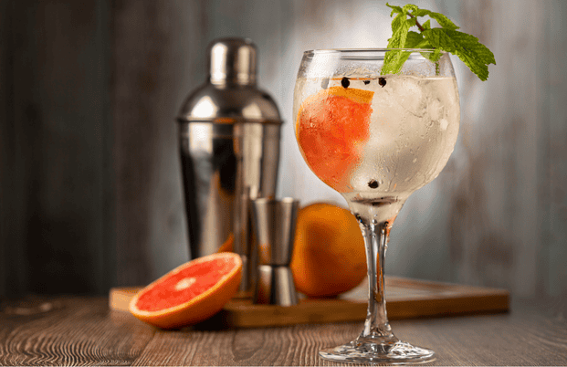 Cocktail gin tonic : variante du cocktail avec du pamplemousse et des feuilles de menthe en décoration sur le verre.