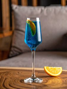 cocktail kir bleu avec du champagne et du curaçao, dans un verre avec un zeste d'orange