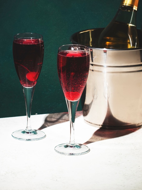 Cocktail Kir Royal, un apéritif dijonnais à base de vin pétillant et crème de cassis, servi dans des flûtes.