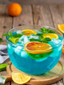 cocktail punch bleu avec du rhum et du curaçao servi dans une vasque avec des fruits