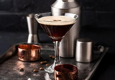 Cocktail Espresso Martini à base de vodka, de liqueur de café, d'expresso et de sirop de cane, dans un verre à cocktail.