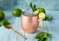 Cocktail Moscow Mule à base de vodka, de ginger beer et de jus de citron vert, dans une timbale avec des glaçons.