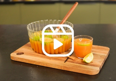 Punch à base de rhum, de nectars de goyave, mangue et fruits de la passion, présenté dans un saladier avec du citron vert.