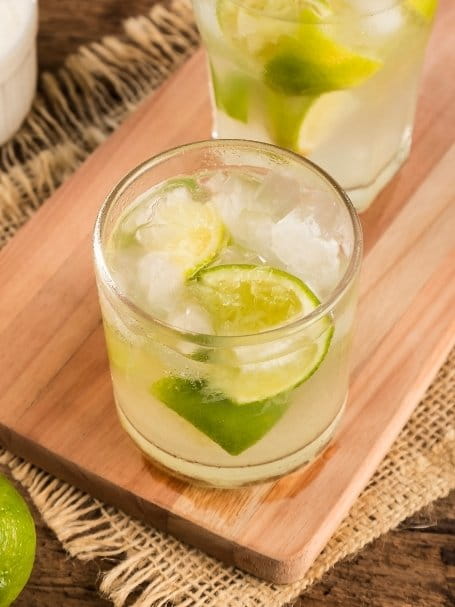 Cocktail Virgin Caipirinha dans un verre old fashioned, à base de rhum désalcoolisé, de sirop de canne et d'un citron vert, avec de la glace pilée.