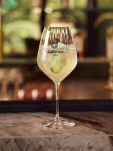 Cocktail sans alcool Virgin Hugo Spritz à base de Bulles sans alcool Jaillance, de sirop de fleur de sureau et de citron vert, dans un grand verre à vin.
