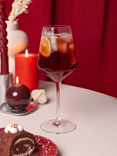 Cocktail Spritz Cassis à la française par l'Héritier-Guyot, à base de crème de cassis, de crémant et d'eau gazeuse, dans un verre ballon.