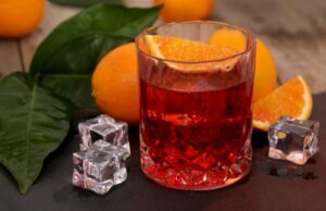 Cocktail au vermouth servi dans un verre old fashioned, avec une tranche d'orange