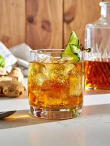 Cocktail Cognac Summit à base de Cognac, de limonade, de gingembre, et de citron vert avec une épluchure de concombre.