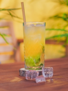 Cocktail Caipirinha au fruit de la passion, présenté dans un grand verre.