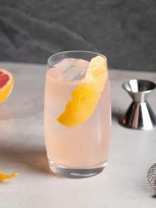 Cocktail Paloma avec de la Tequila servi dans un verre long drink avec un zeste de pamplemousse