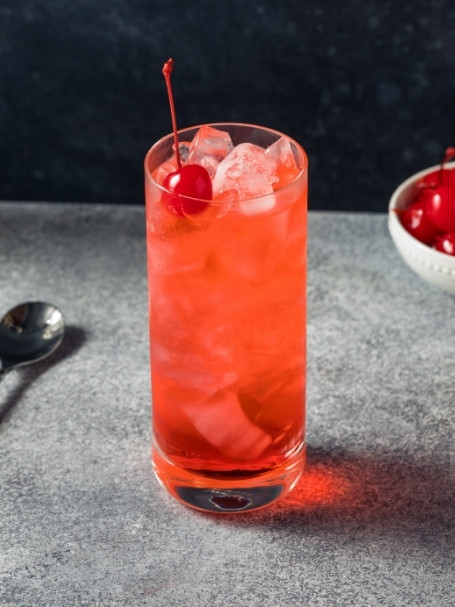 Cocktail Dirty Shirley dans un verre long drink, à base de Vodka Poliakov, du sirop de grenadine Sirop Sport, puis un soda saveur citron-citron vert.