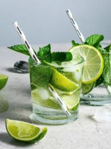 Cocktail Mojito vanille avec du rhum blanc servi dans un verre avec des glaçons et citron vert